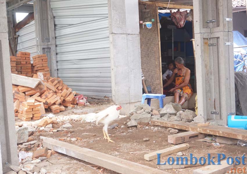 SIAPKAN MAKAN SIANG: Salah seorang warga Lingkungan Tegal, Kecamatan Sandubaya, Kota Mataram memasak untuk makan siang di Risha yang dibangun, kemarin.