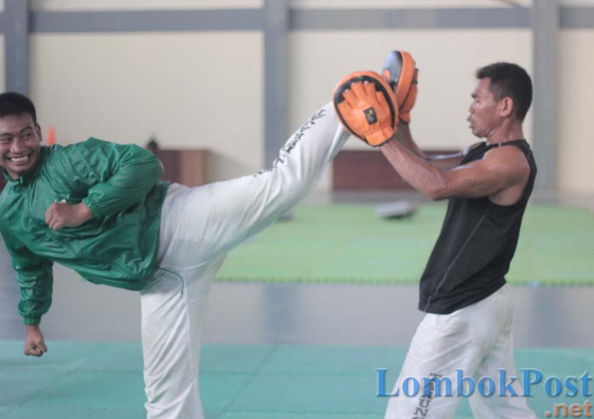 BERHARAP DIPULANGKAN: Atlet tarung derajat NTB Kurniawan (kiri) melatih tendangannya saat latihan di Padepokan Pencak Silat GOR 17 Desember Mataram, tahun 2018 lalu.