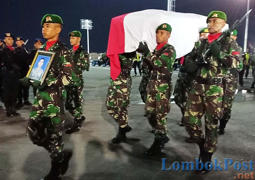 PENGHORMATAN TERAKHIR: Peti jenazah Serda Mirwariyadi, saat tiba di LIA disambut dengan upacara militer yang dipimpin Danrem 162/WB Kolonel CZI Ahmad Rizal Ramdhani, tadi malam (8/3).