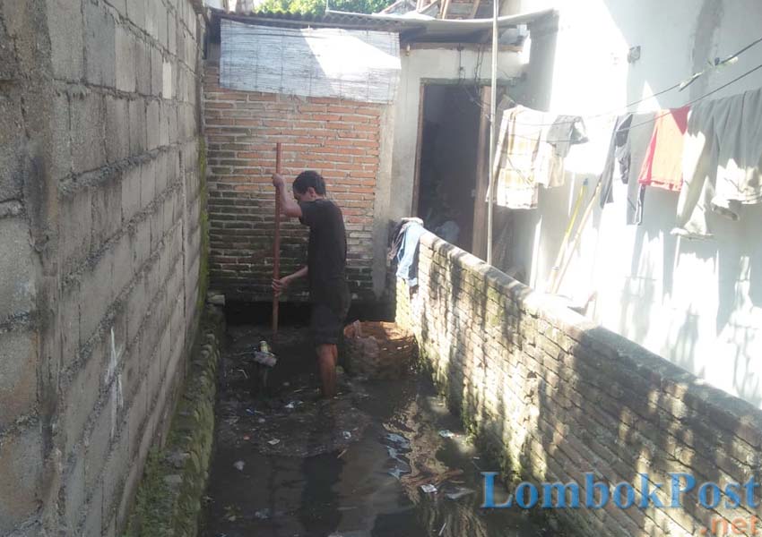 SURGA NYAMUK: Seorang warga tengah membersihkan lingkungannya dari genangan air dan sarang nyamuk di Lendang Kelor, Sayang-Sayang, beberapa waktu lalu.