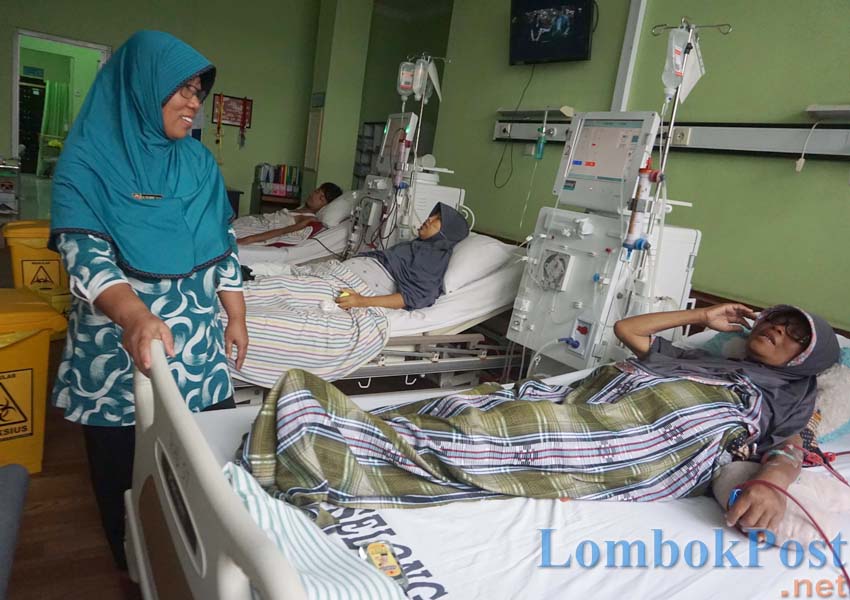 CUCI DARAH: Kepala Ruangan Hemodialisa RSUD dr R Soedjono Selong Hj Siti Jauhari (kanan) sedang bercanda dengan pasiennya, Sabtu (9/3).