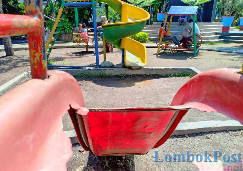 RUSAK: Sebuah lubang terlihat di salah satu fasilitas CPG di Taman Sangkareang. Sementara beberapa orang dewasa ikut memakai fasilitas bermain yang lain, kemarin (1/3).