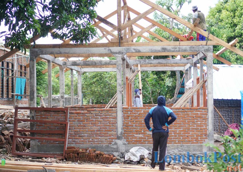 HAMPIR JADI: Tukang bangunan terlihat sedang menyelesaikan pembangunan RTG dana bantuan tahap pertama di Desa Obel-obel, Kecamatan Sambelia, belum lama ini.