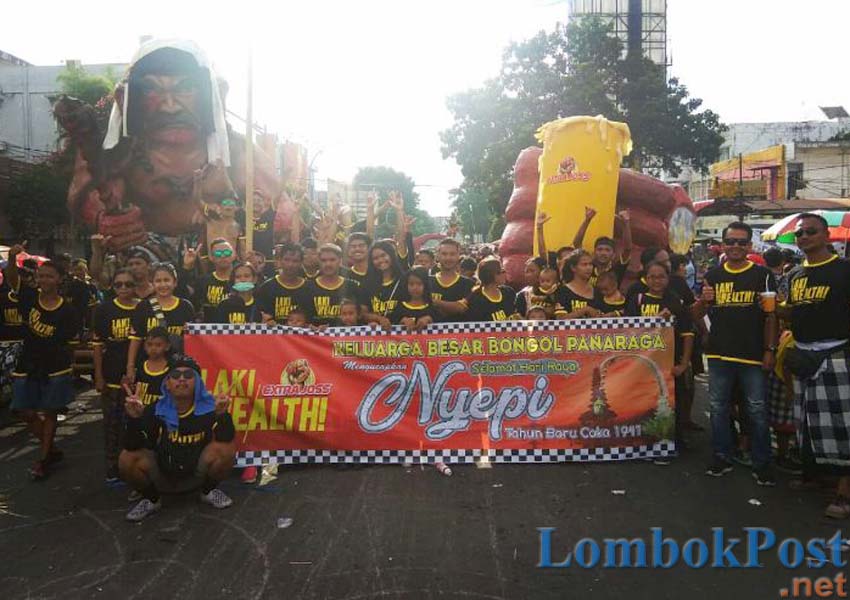 BANGKITKAN SEMANGAT LAKI: Sejumlah peserta pawai Ogoh-Ogoh di Jalan Pejanggik Cakranegara berfoto di depan patung Ogoh-ogoh dan patung gelas berisi Extra Joss Rabu (6/3) lalu.