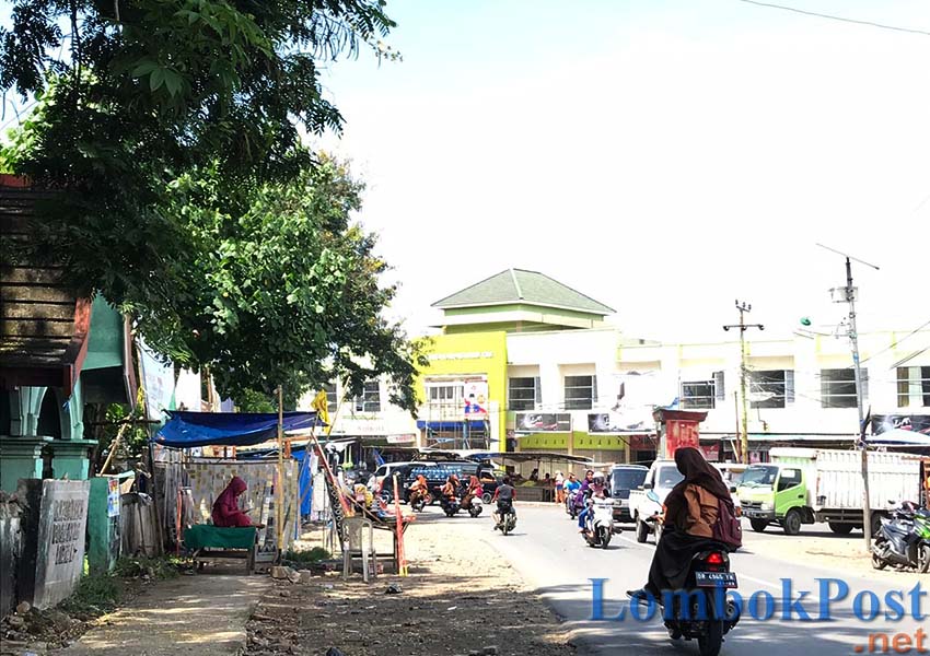 TAK MAU PERGI: Sejumlah PKL terlihat masih berjualan di trotoar depan pemakaman umum Keruak di sekitar Pasar Keruak, kemarin (12/4).