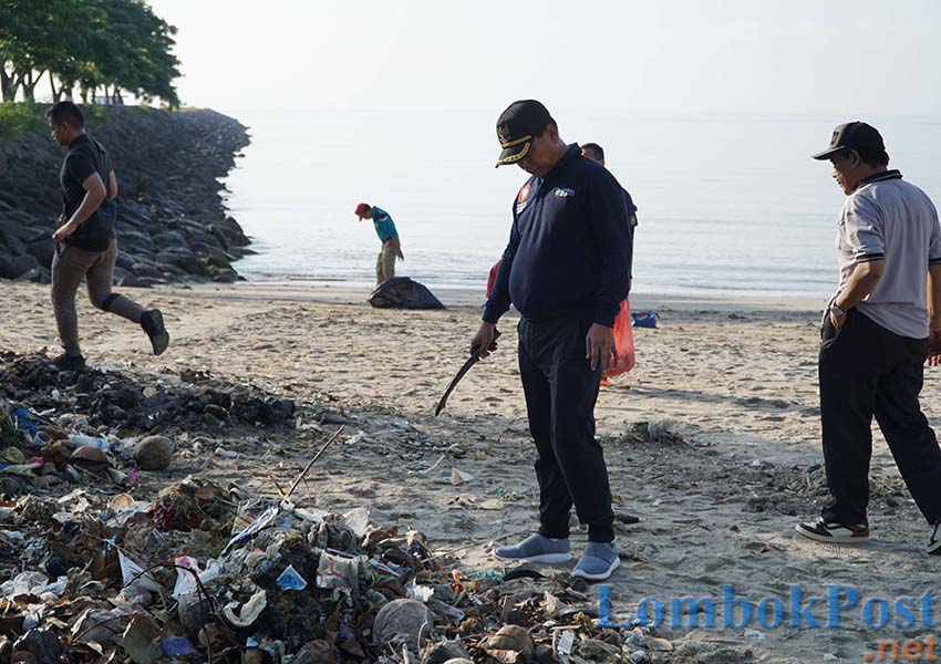 BERSIHKAN SAMPAH: Bupati Lotim HM Sukiman Azmy sedang berdiri di hadapan tumpukan sampah di pantai Labuhan Haji, kemarin (12/4).