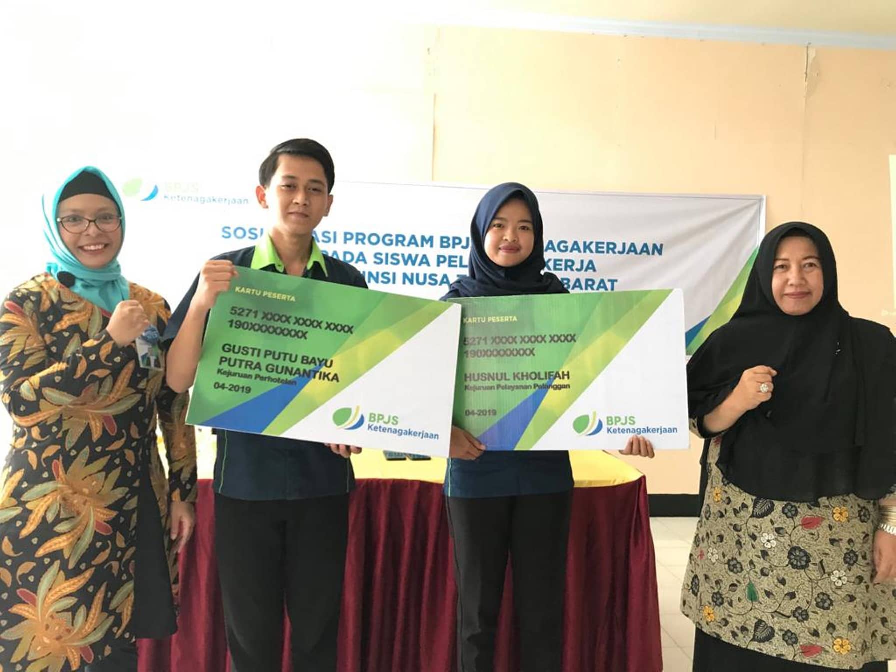 SERAHKAN KARTU PESERTA: Kabid Pelayanan BPJS Ketenagakerjaan Cabang NTB Yulia Ika Wardani (kiri) saat menyerahkan kartu peserta BPJSTK ke siswa BLK, beberapa
