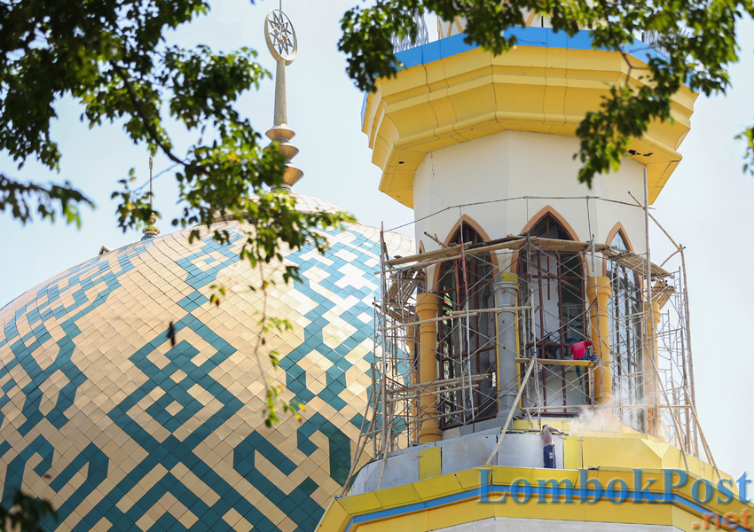 BERBAHAYA: Tiga orang pria bekerja untuk perbaikan salah satu menara Islamic Center yang dihancurkan gempa, di Kota Mataram, beberapa waktu lalu.