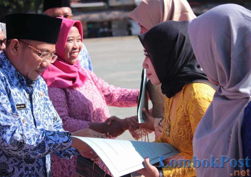 BERI PENGHARGAAN: Bupati KLU H Najmul Akhyar memberikan penghargaan pada salah satu perempuan inspiratif KLU dalam upacara peringatan Hari Kartini ke 140, kemarin (22/4)