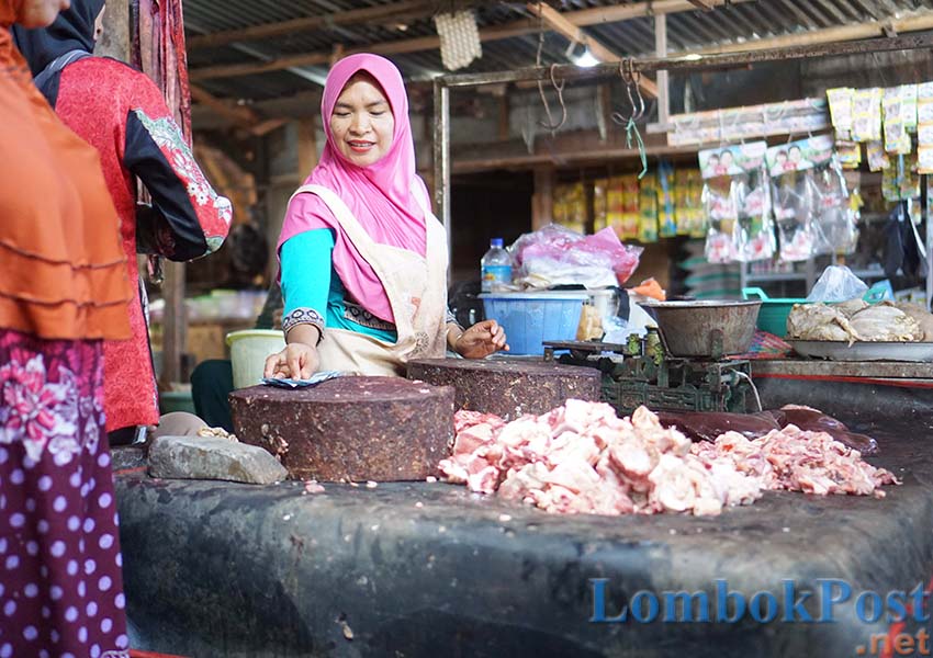 PEDAGANG DAGING: Seorang pedagang daging sedang melakukan transaksi jual beli di Pasar Umum Pancor, Kelurahan Pancor, Kecamatan Selong, kemarin (3/5).