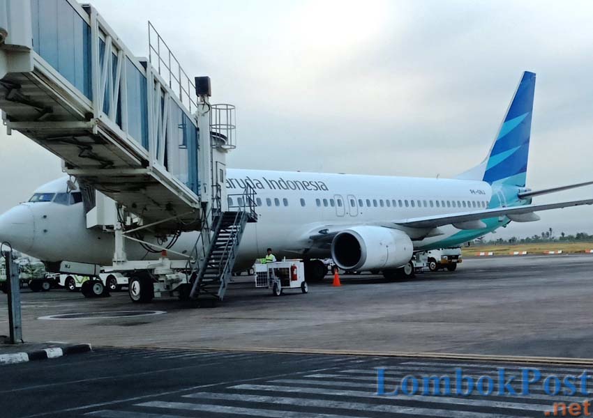 MENURUNKAN PENUMPANG: Sebuah pesawat Garuda Indonesia, saat menurunkan penumpang melalui garbarata LIA, beberapa waktu lalu.