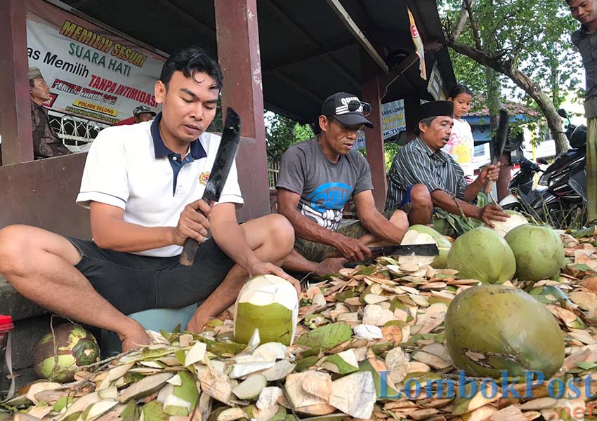 KUPAS KELAPA MUDA: Para pedagang sedang mengupas kelapa muda jualannya di simpang empat Rakam, depan Polsek Selong, kemarin (8/5).