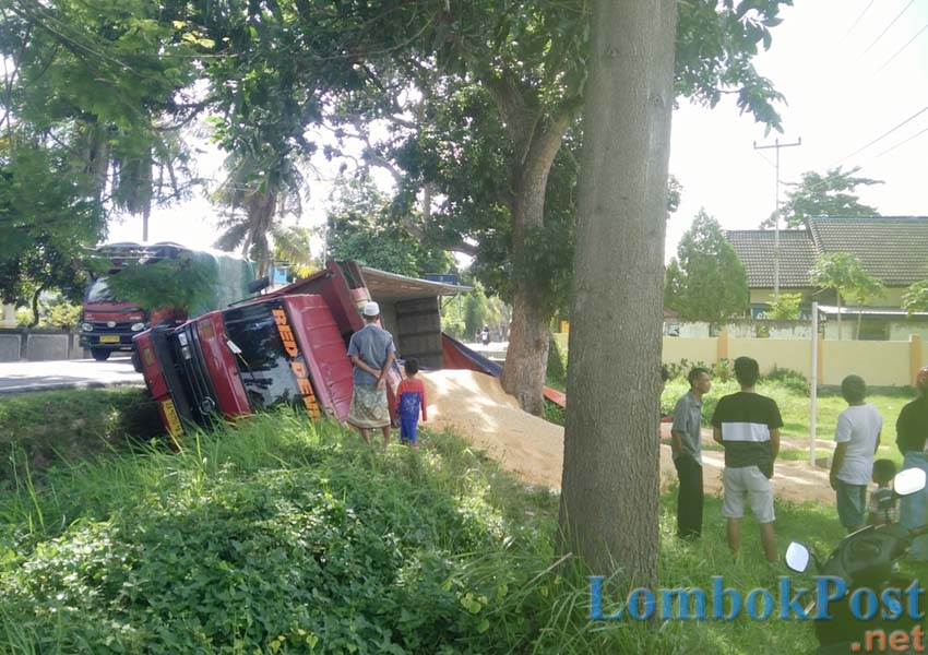 TERBALIK: Beginilah kondisi truk pengangkut jagung yang terbalik di depan Lapangan Umum Jembatan Kembar, kemarin
