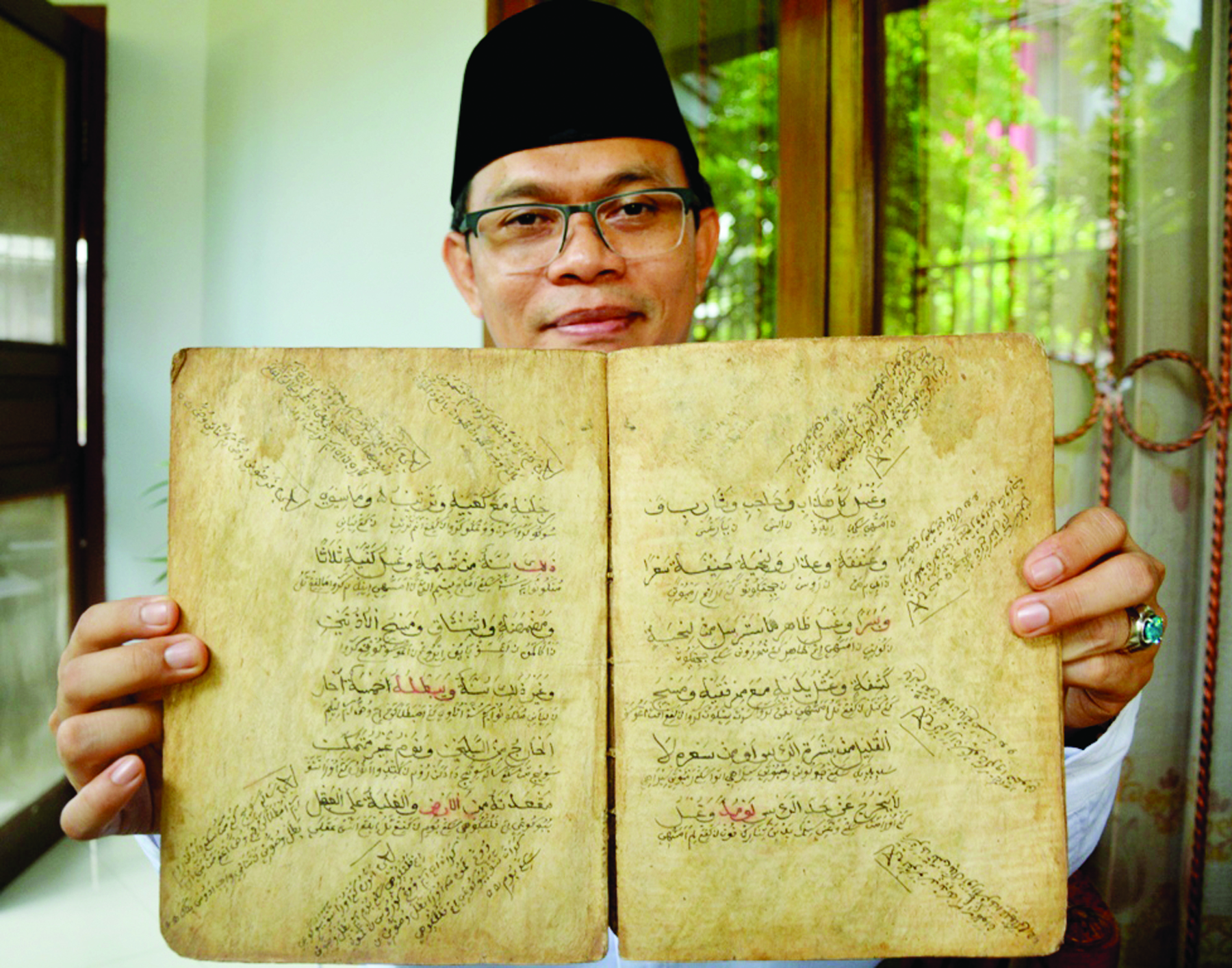 KITAB ASSAMARKANDI: Jamaluddin menunjukkan kitab Assamarkandi, salah satu sumber yang digunakan dalam menggali sejarah Islam di Lombok.