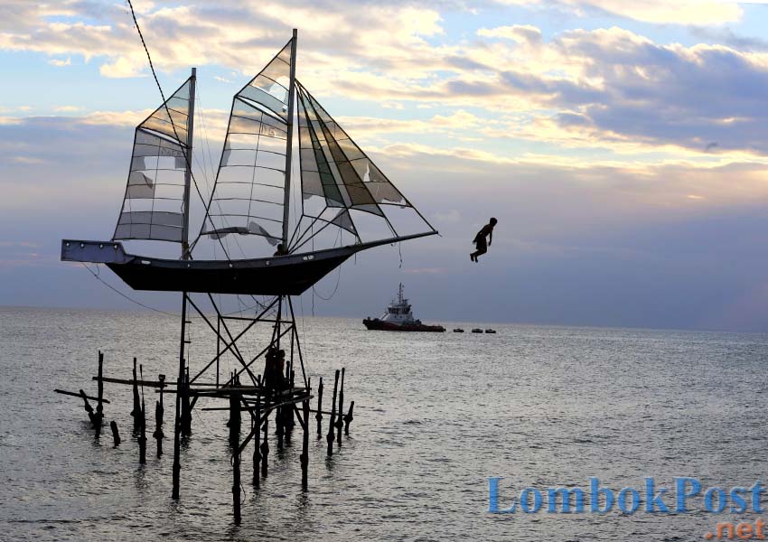 TIDAK TERAWAT: Seorang anak melompat dari miniatur perahu layar di pantai Ampenan, Kota Mataram, beberapa hari lalu. Miniatur yang menjadi ikon pantai Ampenan itu kondisinya tidak terawat dan tak lagi enak dipandang.
