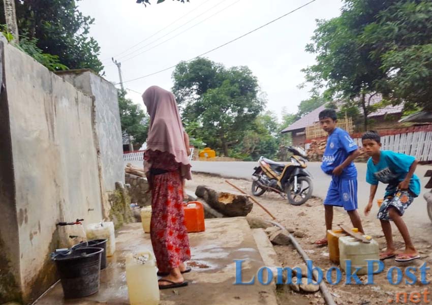 AIR BERSIH MENIPIS: Warga Dusun Ndano Ndere, Desa Bajo, Kecamatan Soromandi, Kabupaten Bima mengambil air di bak penampungan di Kecamatan Donggo, beberapa waktu lalu.