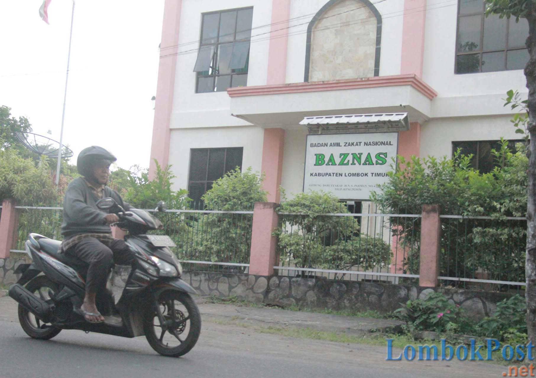 Salah seorang warga melintas di depan kantor Baznas Lotim, beberapa waktu lalu.