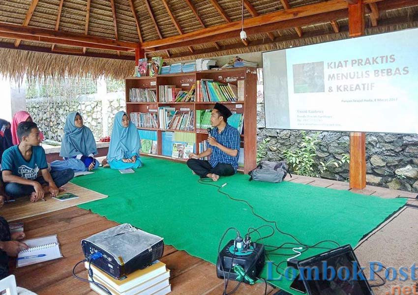 LITERASI: Yusuf Tantowi (berdiri) salah seorang penulis membagikan ilmunya kepada para pelajar di Berugak Buku.