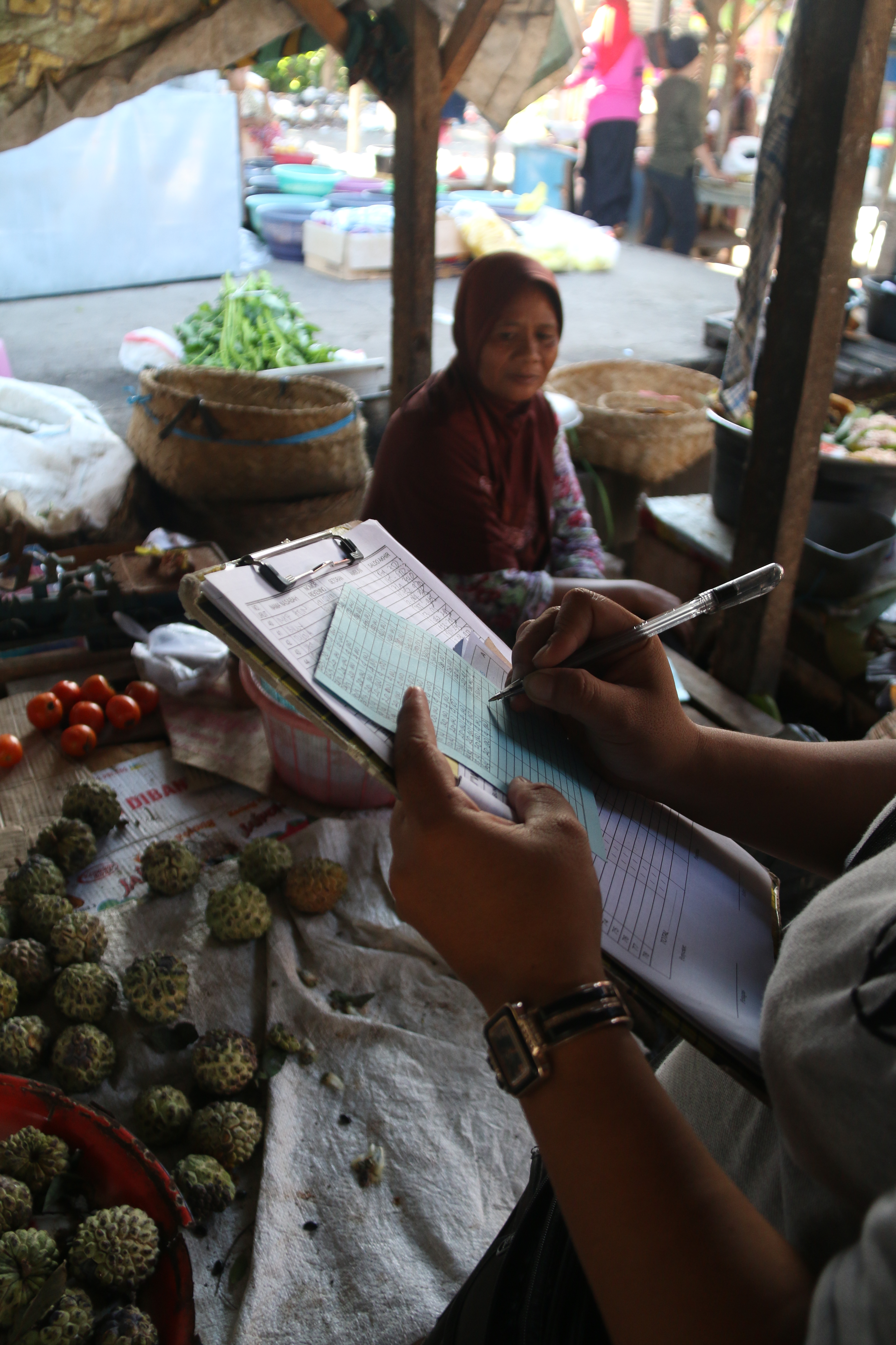 IVAN/ LOMBOK POST Seorang pedagang membayar setoran kepada petugas koperasi di pasar Duman, Lombok Barat, Minggu (28/7).