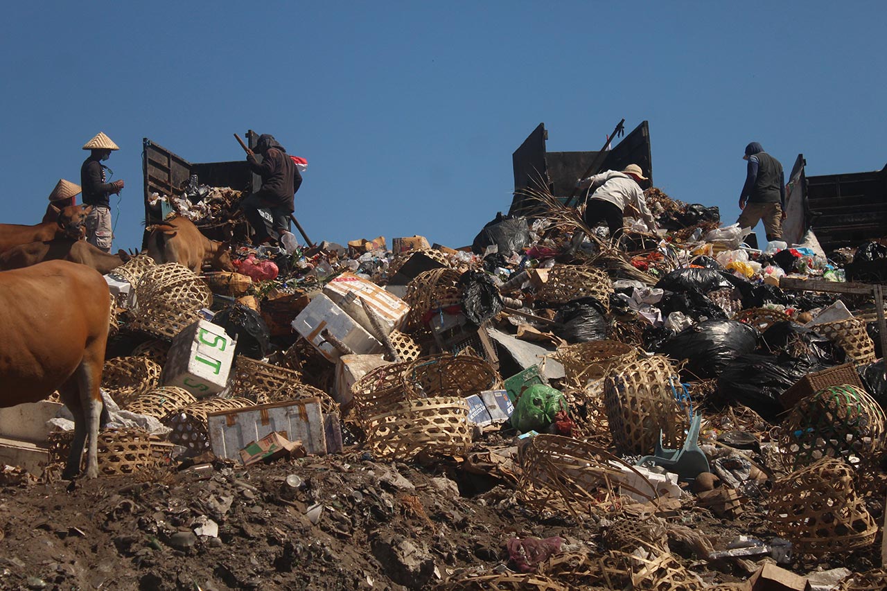 BELUM OPTIMAL: Sejumlah tukang angkut sampah tengah menurunkan sampah dari kendaraan roda tiga di TPST Gili Trawangan, Minggu lalu (19/8).