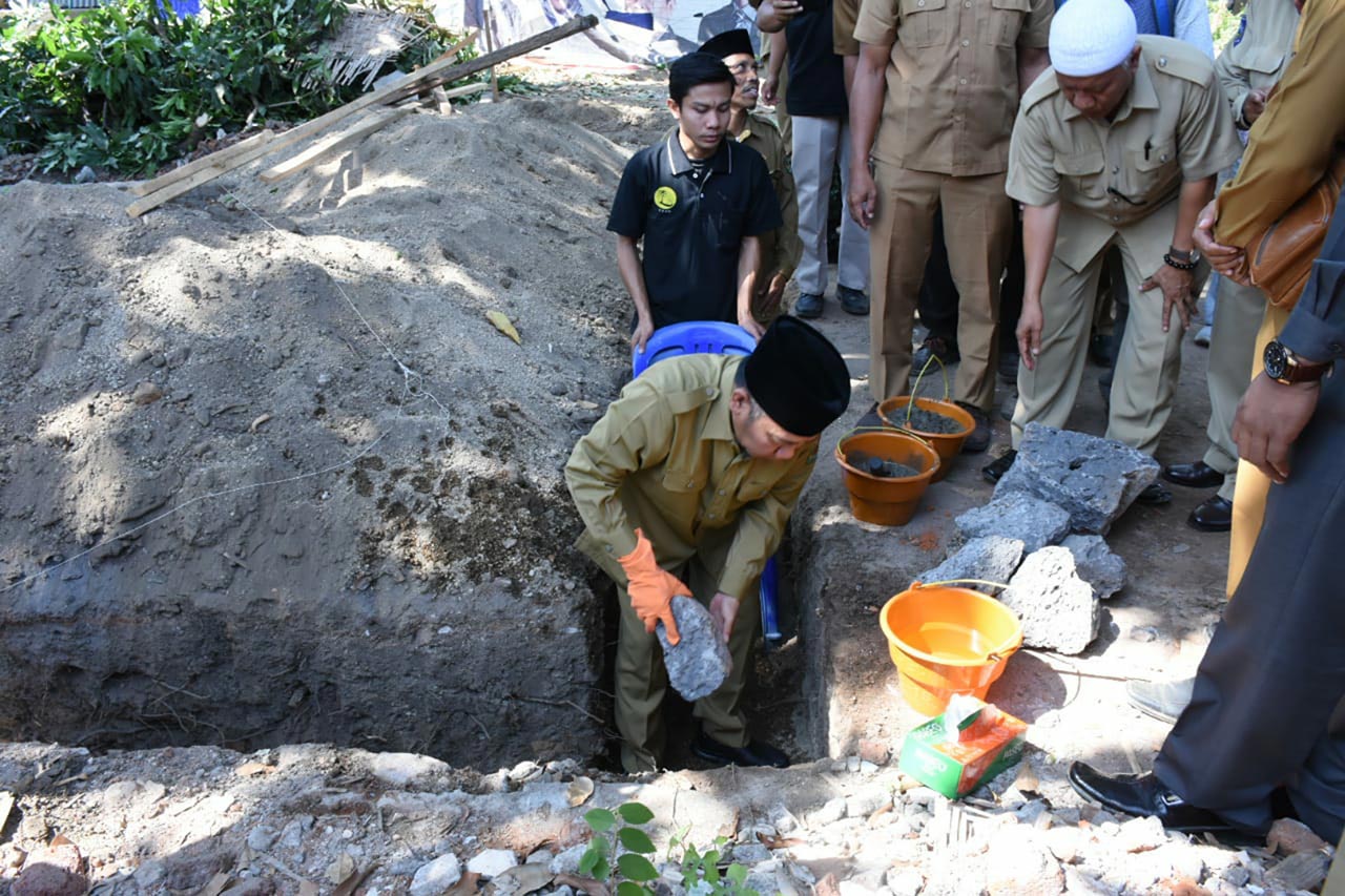 PELETAKAN BATU PERTAMA: Bupati KLU H Najmul Akhyar melakukan peletakan batu pertama pembangunan rumah produksi VCO dan gudang minyak goreng di Desa Sokong, Kecamatan Tanjung, kemarin (26/8).