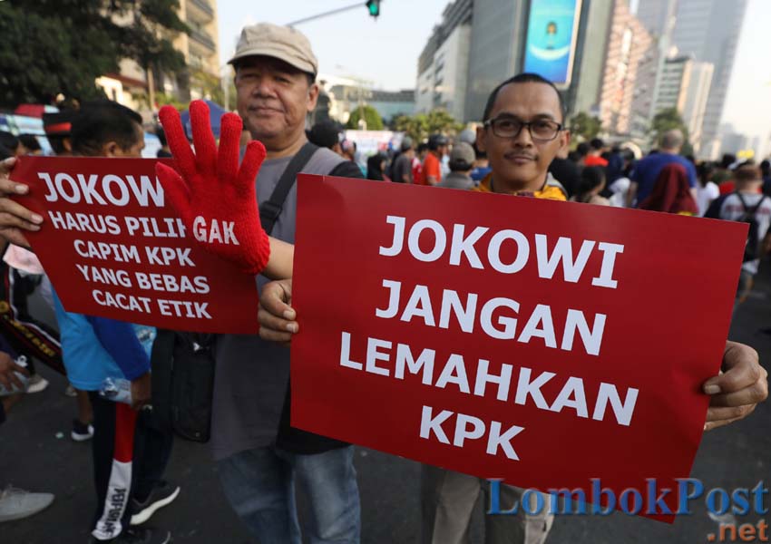 Aktivis yang tergabung dalam Koalisi Masyarakat Sipil membentangkan spanduk ketika melakukan aksi saat Hari Bebas Kendaraan Bermotor (HBKB) di kawasan Bundaran HI, Jakarta, Minggu (1/9/2019). Dalam aksinya mereka meminta Presiden Joko Widodo agar berani m