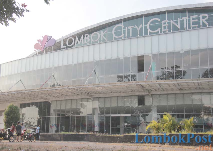 MANGKRAK: Sejumlah pemuda terlihat  nongkrong di depan LCC  beberapa waktu lalu. Gedung yang menjadi KSO antara PT Tripat dan PT Bliss itu sedang diusut Kejati NTB.