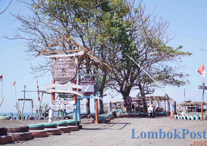 TERTATA RAPI: Seorang pengunjung sedang keluar dari palang pintu destinasi wisata pantai Maik Anyir yang dipenuhi beberapa spot foto di Kelurahan Ijobalit, Kecamatan Labuhan Haji, belum lama ini.
