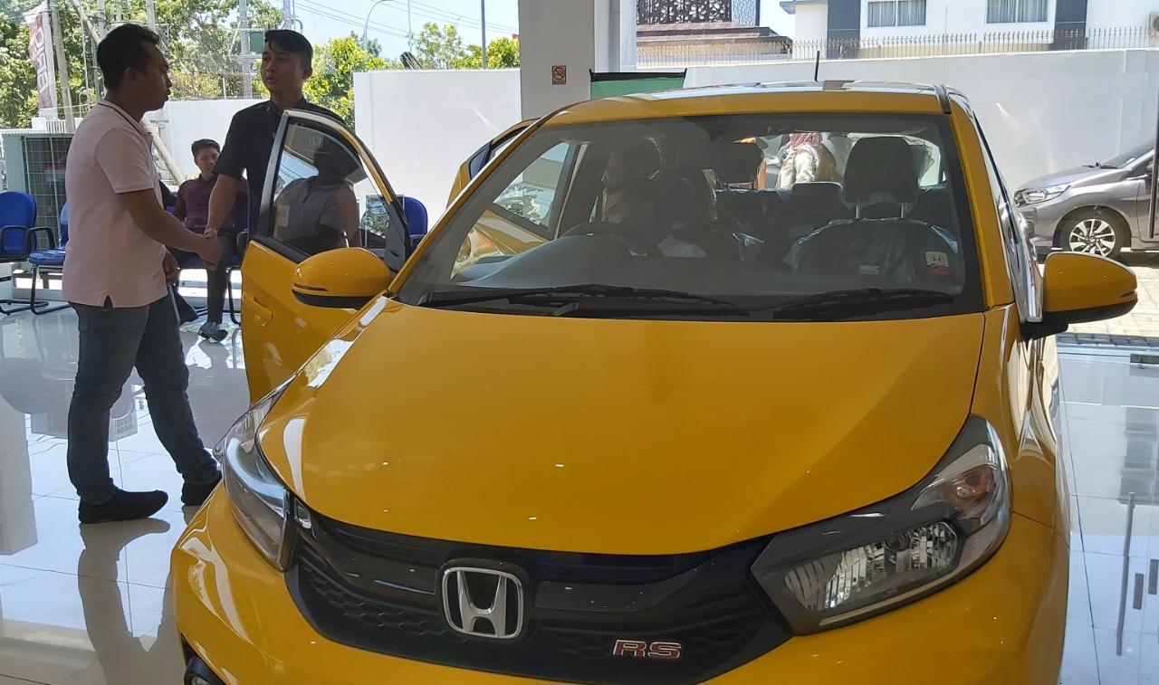 NURUL/LOMBOK POST LIHAT MOBIL: Seorang sales menemani konsumen melihat-lihat mobil, di showroom Honda Naga Motor, Selasa (18/2).