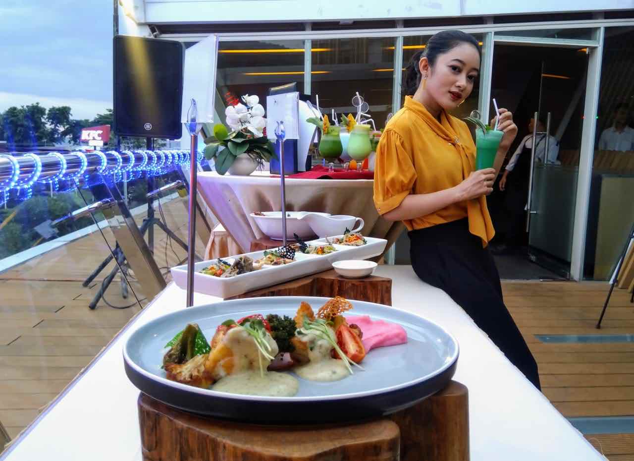 MEWAH, LEZAT DAN TERJANGKAU: Salah satu pengunjung Hotel Aruna siap menikmati hidangan mewah yang ada di Kayu Manis Rooftop Cafe, Jumat (28/2) (TONI/LOMBOK POST)