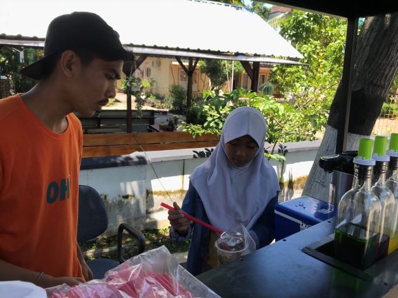 MEMBANTU KELUARGA: Siswa SDN 3 Selong Hamida (kanan) sedang meracik minuman Jelly Potter bersama kakaknya Agus (kanan) di kedai depan rumahnya Jl TGKH Zainuddin Abdul Majid, Kecamatan Selong, Rabu (18/3).