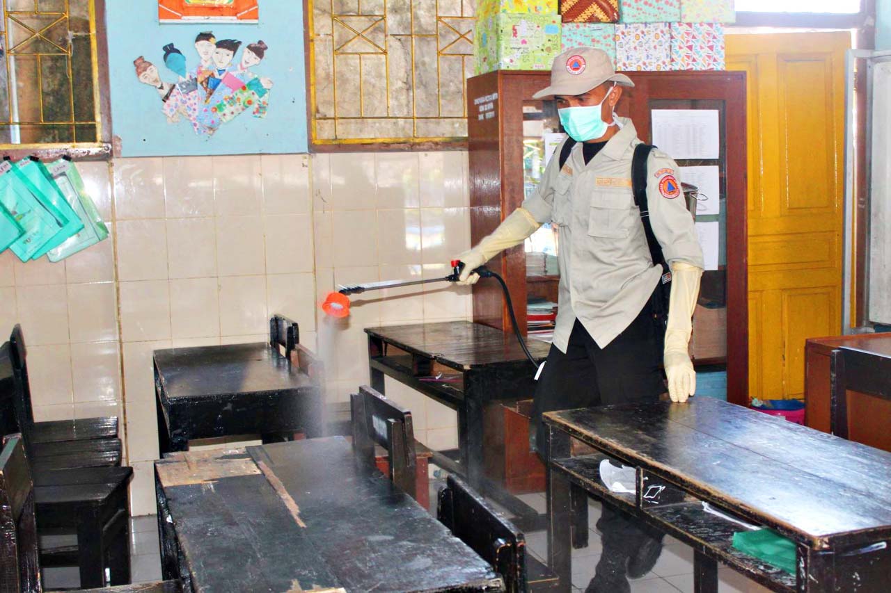 ANTISIPASI KORONA: Seorang petugas BPBD Kota Mataram, sedang menyemprotkan cairan desinfektan di salah satu ruang kelas SDN 32 Mataram di Dasan Agung, Rabu (18/3/2020).