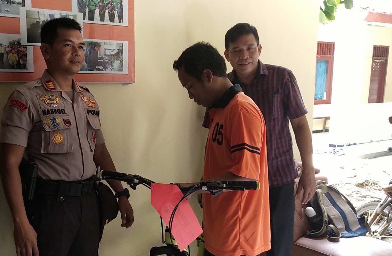 GARA-GARA JUDI ONLINE: Kapolsek Ampenan M Nasrullah (kiri) memperlihatkan sepeda hasil curian Dalek di Mapolsek Ampenan, Jumat (6/3) lalu. (Harli/Lombok Post)