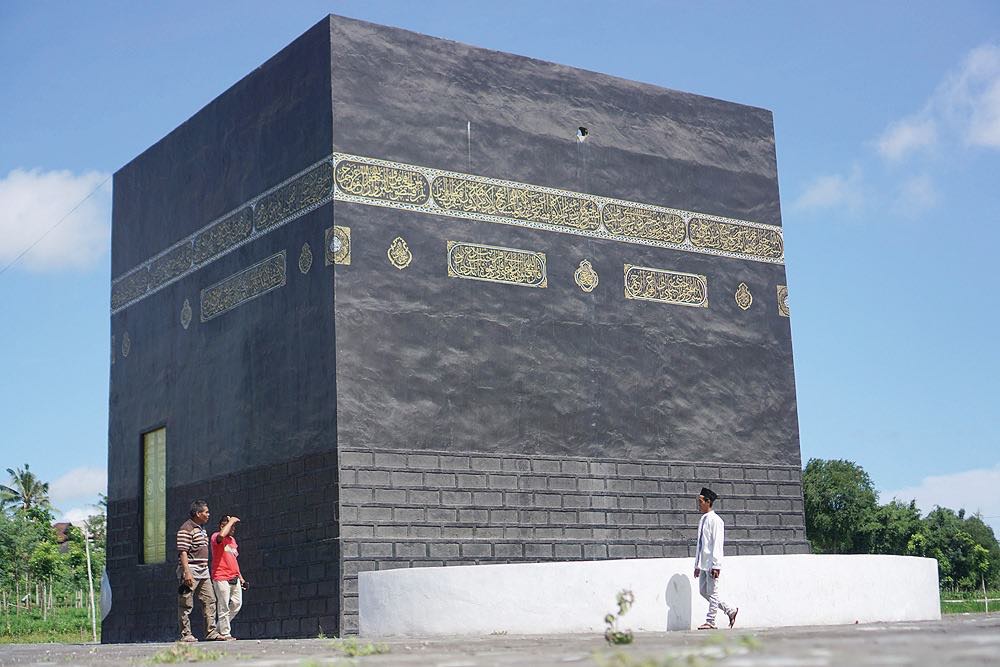 MINIATUR: Seorang pengunjung wisata edukasi Jabal Rahmah terlihat sedang mengitari replica Ka’bah di Desa Jango, Kecamatan Janapria, Lombok Tengah, kemarin (15/3). (Fatih/Lombok Post)
