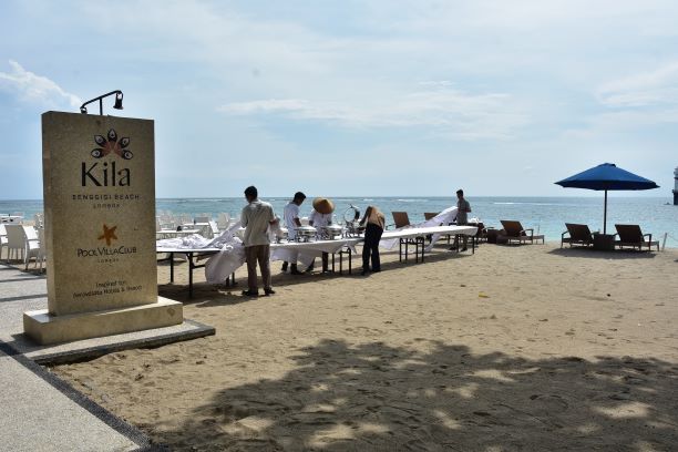IKON LOMBOK BARAT: Beberapa pekerja hotel merapikan meja di pesisir pantai Senggigi, Lombok Barat, kemarin. Pantai Senggigi belakangan semakin sepi. (IVAN/ LOMBOK POST)