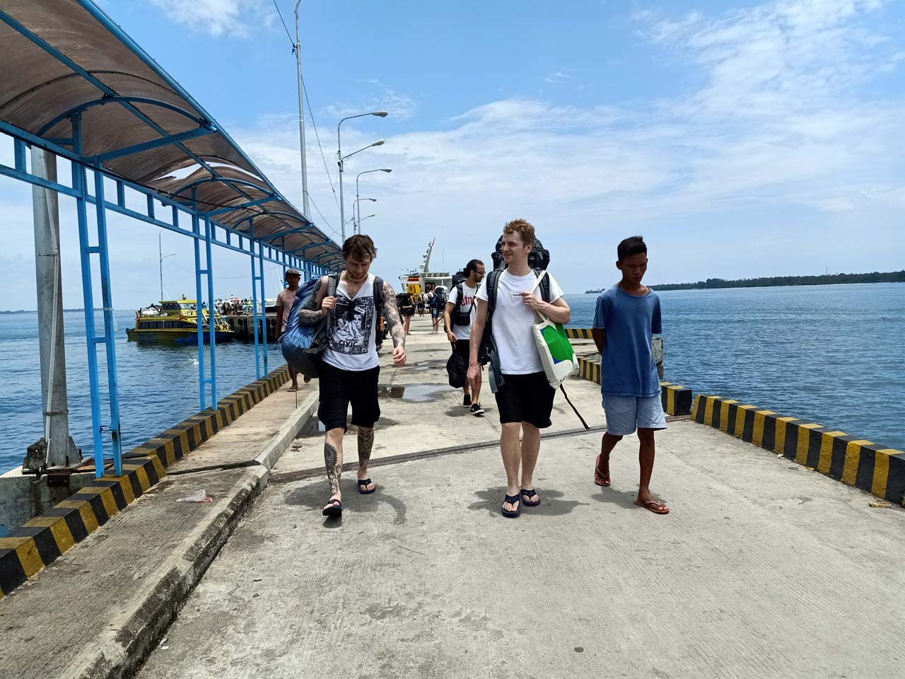 KEMBALI DARI GILI: Sejumlah wisatawan mancanegara (wisman) saat tiba di Bangsal usai berwisata di Gili Trawangan, Kamis (5/3/2020).