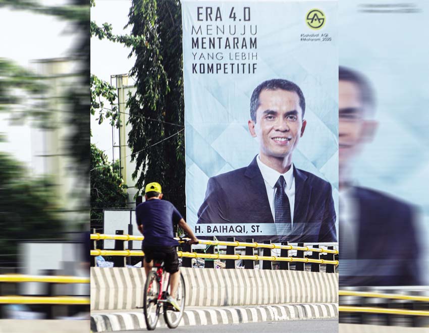 SIAP BERTARUNG: Seorang pesepeda sedang melintas di depan baliho bergambar Baihaqi di Kota Mataram, belum lama ini.