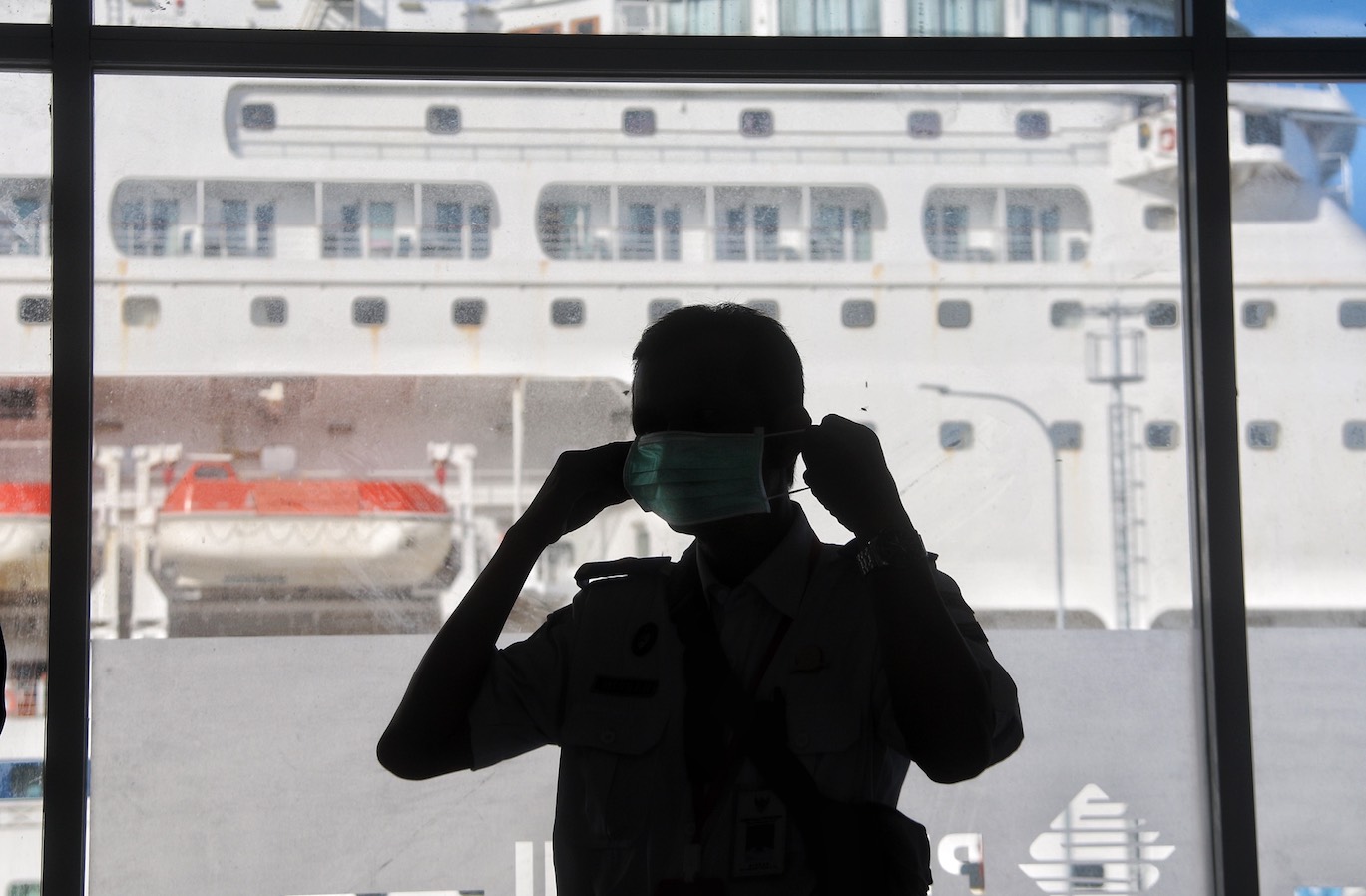 Seorang petugas mengenakan masker  untuk mencegah penularan korona saat menyambut kedatangan penumpang Kapal Pesiar MV Columbus di Pelabuhan Gili Mas Lembar Lombok Barat Selasa (10/3/20).(Ivan/Lombok Post)