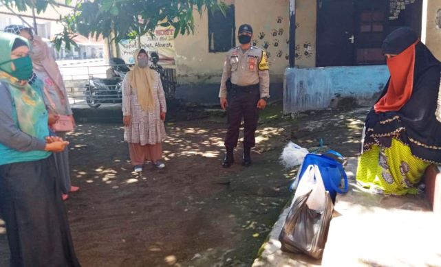 SEMOGA BERMANFAAT: Ibu-ibu Kelurahan Tiwugalih, Praya menyalurkan bantuan paket sembako bagi keluarga ODP dan PDP, kemarin (21/4). (dedi/Lombok Post)
