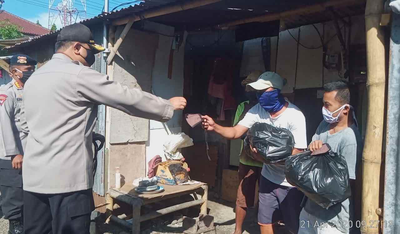 BAGIKAN SEMBAKO: Kapolda NTB Irjen Pol Tomsi Tohir (kiri) memberikan sembako kepada masyarakat, Selasa (21/4).  (Harli/Lombok Post)