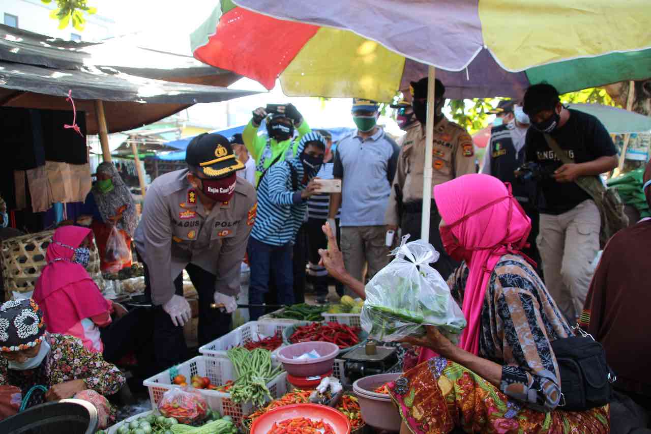 IMBAU PEDAGANG: Tim Gugus Tugas Covid-19 saat turun sosialisasi ke Pasar Gerung, Minggu (19/4). (Polres Lobar utuk Lombok Post)