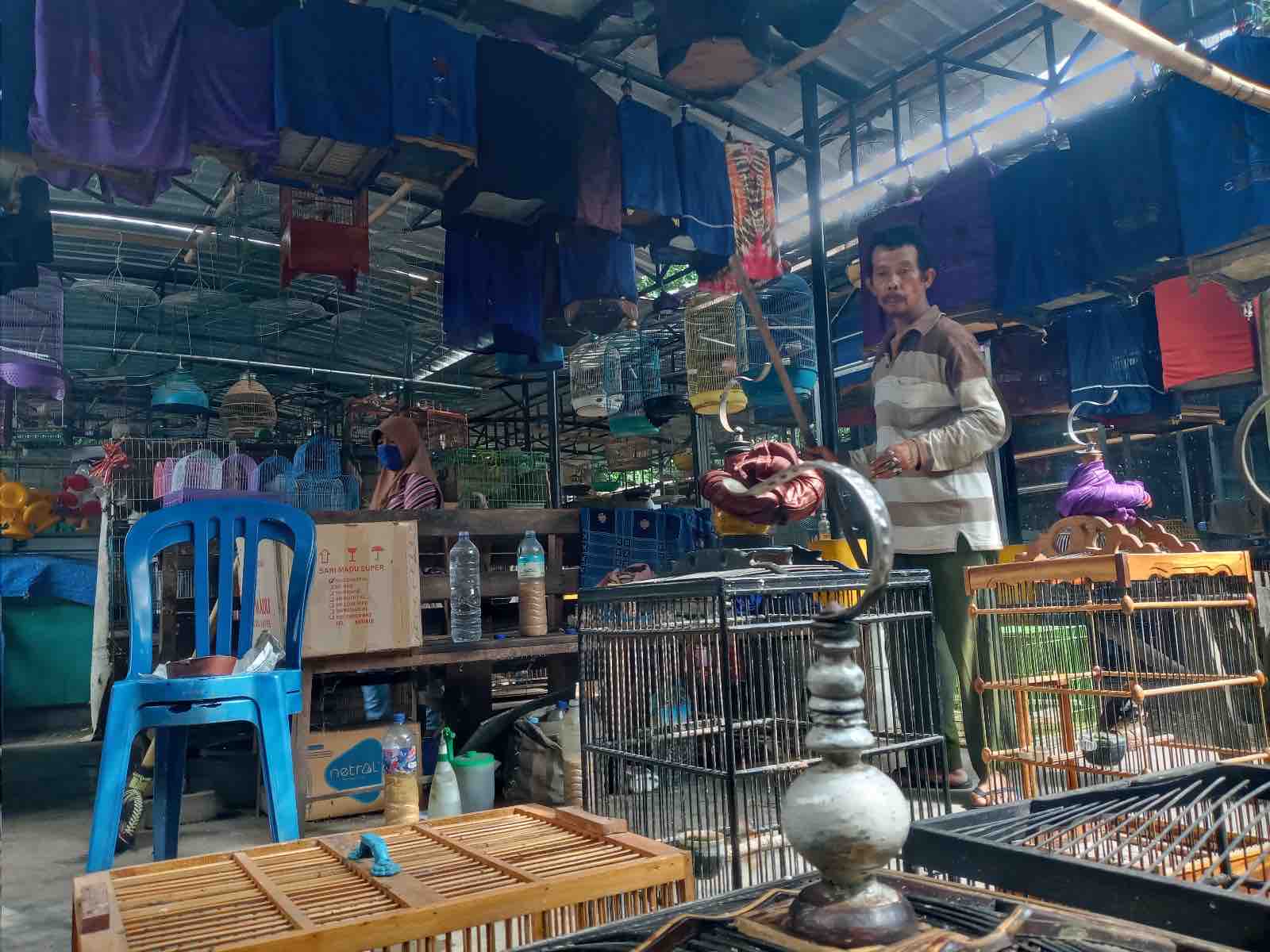 Seorang pedagang merapikan sangkar burung miliknya karena diminta tutup pihak kepolisian di Pasar Burung Cakranegara, beberapa waktu lalu. (Rojai/Lombok Post)