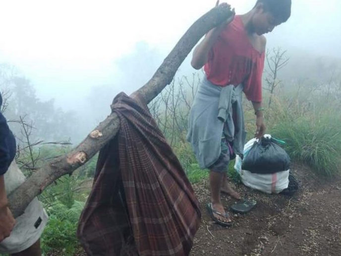 DIEVAKUASI: Sejumlah pemuda Desa Senaru tengah menggotong mayat tanpa identitas di jalur Pelawangan Senaru Sabtu lalu (11/4/2020). Mereka hanya bisa mengevakuasi mayat tersebut hingga pos tiga.
