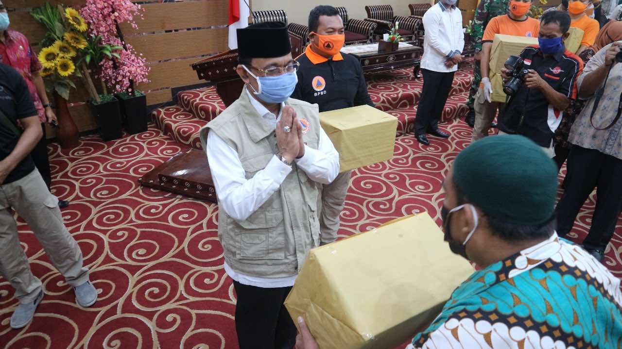 BANTUAN: Wali Kota Mataram H Ahyar Abduh menyerahkan bantuan penanganan Korona ke kepala lingkungan di Aula Pendopo Wali Kota Mataram, Rabu (6/5). (Diskominfo for Lombok Post)