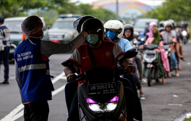 WAJIB MASKER: Pengendara sepeda motor dan roda empat wajib mengenakan masker saat berkendara di jalanan Kota Mataram. (IVAN/LOMBOK POST)