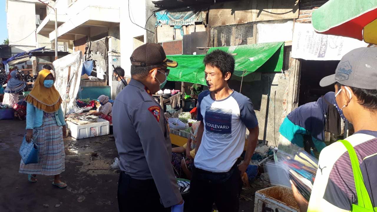 PERANGI COVID-19: Kabagops Polresta Mataram Kompol Taufik (kiri) menegur seorang pengunjung pasar Kebon Roek, Ampenan yang tidak menggunakan masker, (8/5) lalu. Dia diminta untuk pulan dan jangan keluar kalau tidak menggunakan masker. (HARLI/LOMBOK POST)