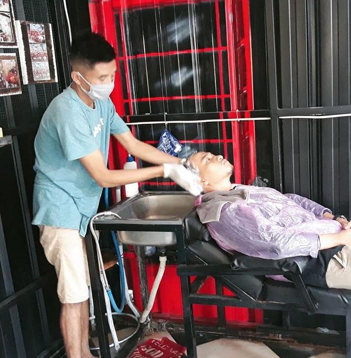 CEGAH KORONA: Seorang pelanggan sedang mencukur rambut di salah satu cabang Bro Barbershop, lengkap dengaan APD sekali pakai, beberapa waktu lalu. Tampak petugas menggunakan masker dan sarung tangan.