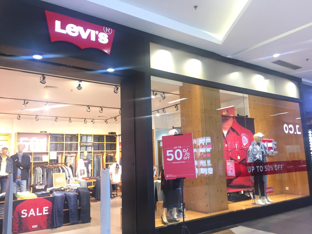 MELAYANI PENGUNJUNG : Karyawan Levi’s Lombok Epicentrum Mall saat menunjukkan produk End of Season Sale kepada pengunjung, kemarin (23/6/2020).