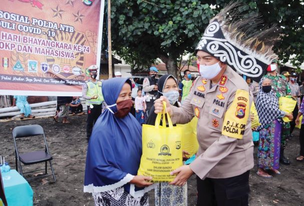 INDAHNYA BERBAGI: Kapolda NTB Irjen Pol M Iqbal memberikan sembako kepada masyarakat di Kampung Nelayan, Pondok Perasi, Ampenan, Mataram, Sabtu (13/6) lalu.( HUMAS POLDA NTB FOR LOMBOK POST)