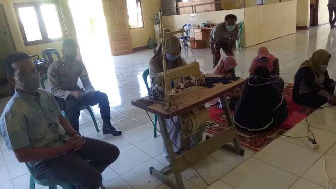KAMPUNG SEHAT: Bhabinkamtibmas Desa Beru, Kecamatan Jereweh mengawasi dan memantau langsung proses pembuatan masker yang digagas pemerintah desa untuk dibagikan kepada warga.( IST/RADAR SUMBAWA)